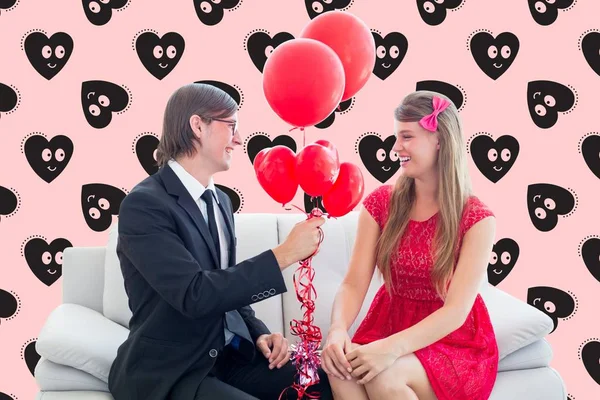 Gelukkig man rode ballonnen geven vrouw — Stockfoto