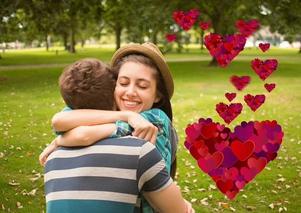 Pareja abrazándose en parque con formas de corazón —  Fotos de Stock