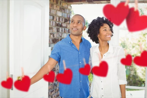 Hängende Herzen und Paar betreten das Haus — Stockfoto