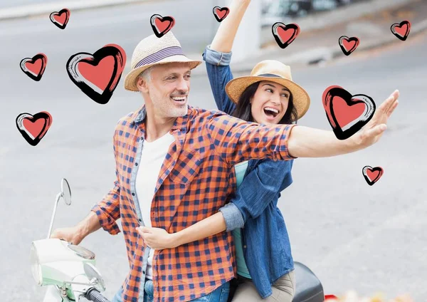 Couple on scooter in street with hearts shapes — Stock Photo, Image