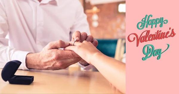 Man putting ring on woman's finger — Stock Photo, Image