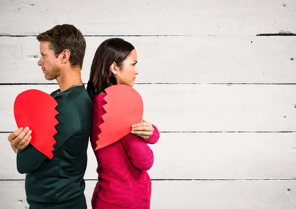 Angry couple holding broken heart — Stock Photo, Image