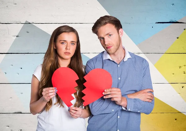 Triste pareja sosteniendo roto corazones — Foto de Stock