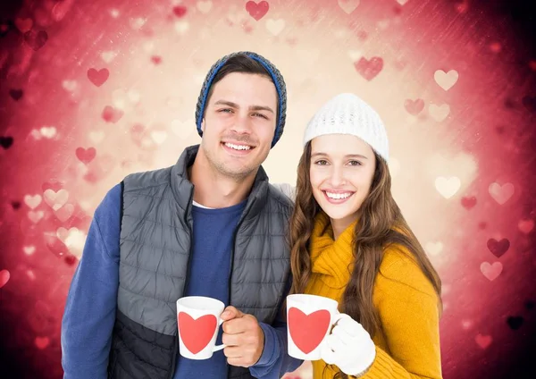 Couple tenant des tasses avec des formes de coeur sur eux — Photo