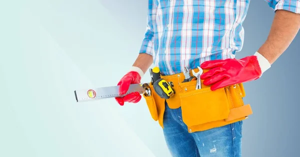 Handyman with tool belt and spirit level — Stock Photo, Image
