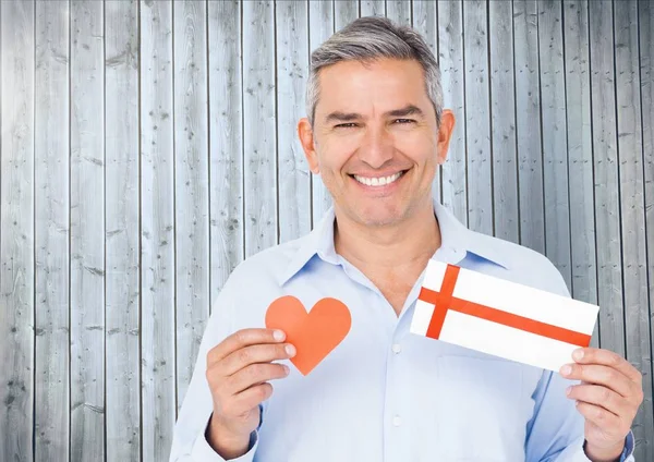 Senior man holding red heart and gift card — Stock Photo, Image