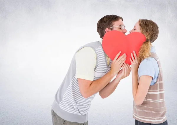 Romantic couple kissing behind heart — Stock Photo, Image