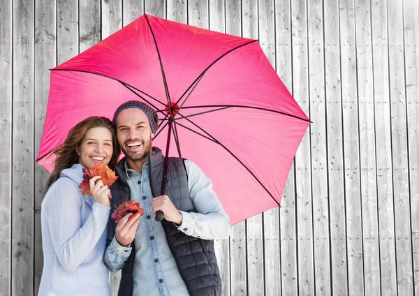 Casal com guarda-chuva contra fundo de madeira — Fotografia de Stock