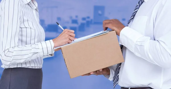 Woman signing a document on arrival of parcel — Stock Photo, Image