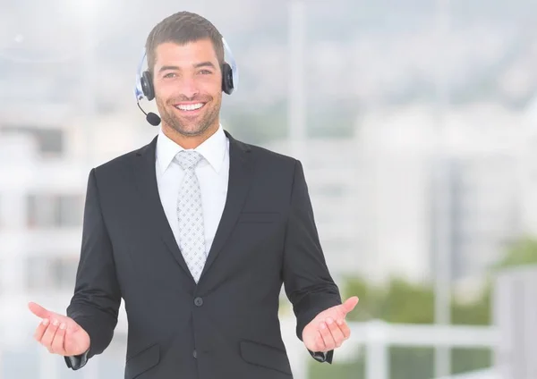 Podnikatel na sobě sluchátka s mikrofonem a s úsměvem — Stock fotografie