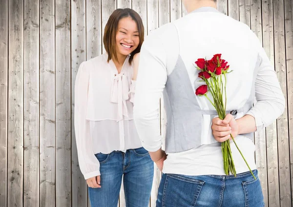 Uśmiechający się para z człowiek ukrywa róże — Zdjęcie stockowe