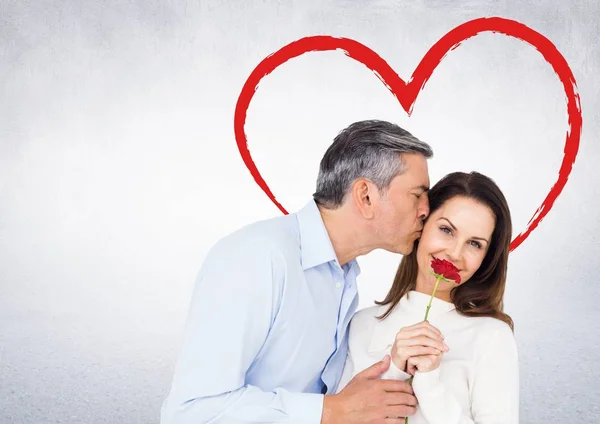 Mature man kissing woman holding rose — Stock Photo, Image