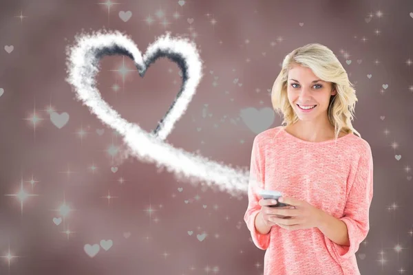 Sonriente mujer mensajes de texto en el teléfono móvil con el corazón blanco generado digitalmente —  Fotos de Stock
