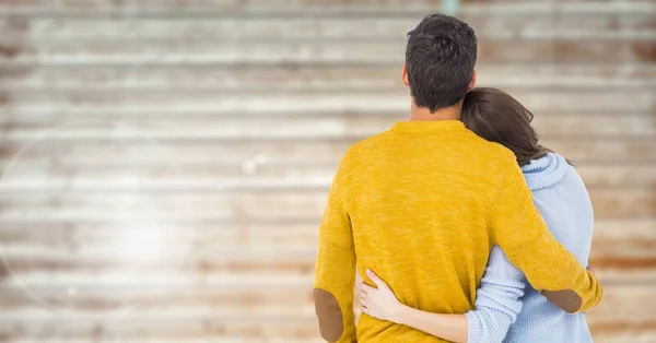 Paar omarmen tegen houten achtergrond — Stockfoto