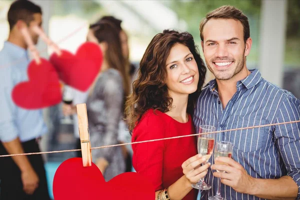 Romantiska par stående med ett glas champagne — Stockfoto