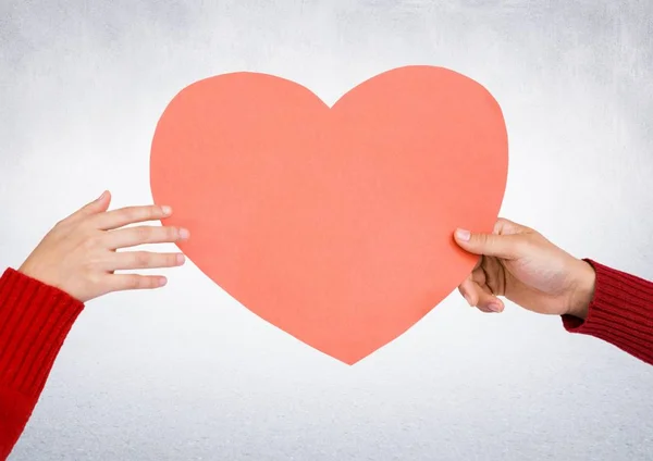 Manos sosteniendo un corazón rojo — Foto de Stock