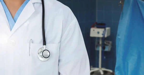 Läkare står i operationssalen med stetoskop — Stockfoto