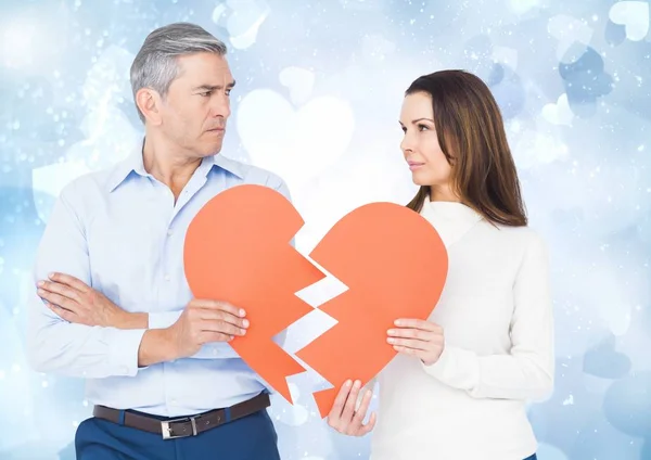 Mature couple holding a broken heart — Stock Photo, Image