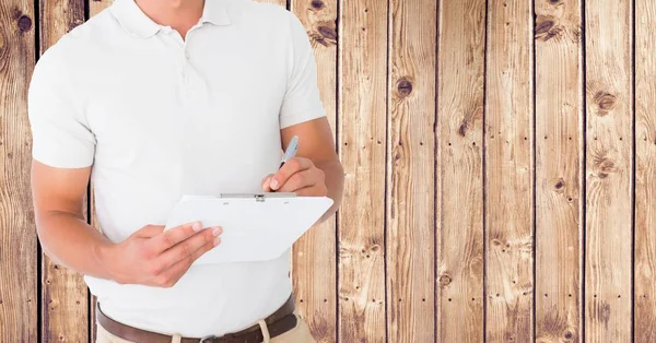 Uomo di consegna che scrive sugli appunti sullo sfondo di legno — Foto Stock