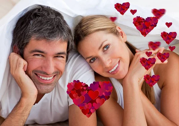 Casal feliz deitado na cama em casa — Fotografia de Stock