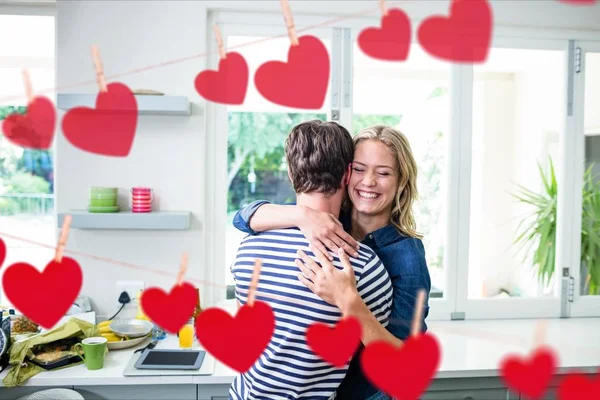 Casal abraçando uns aos outros na cozinha — Fotografia de Stock