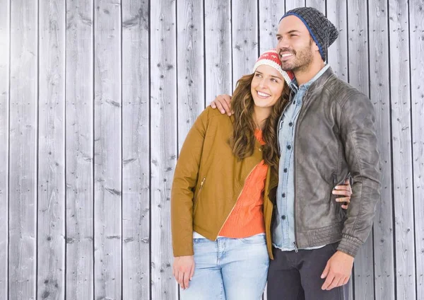 Couple standing against wooden background — Stock Photo, Image