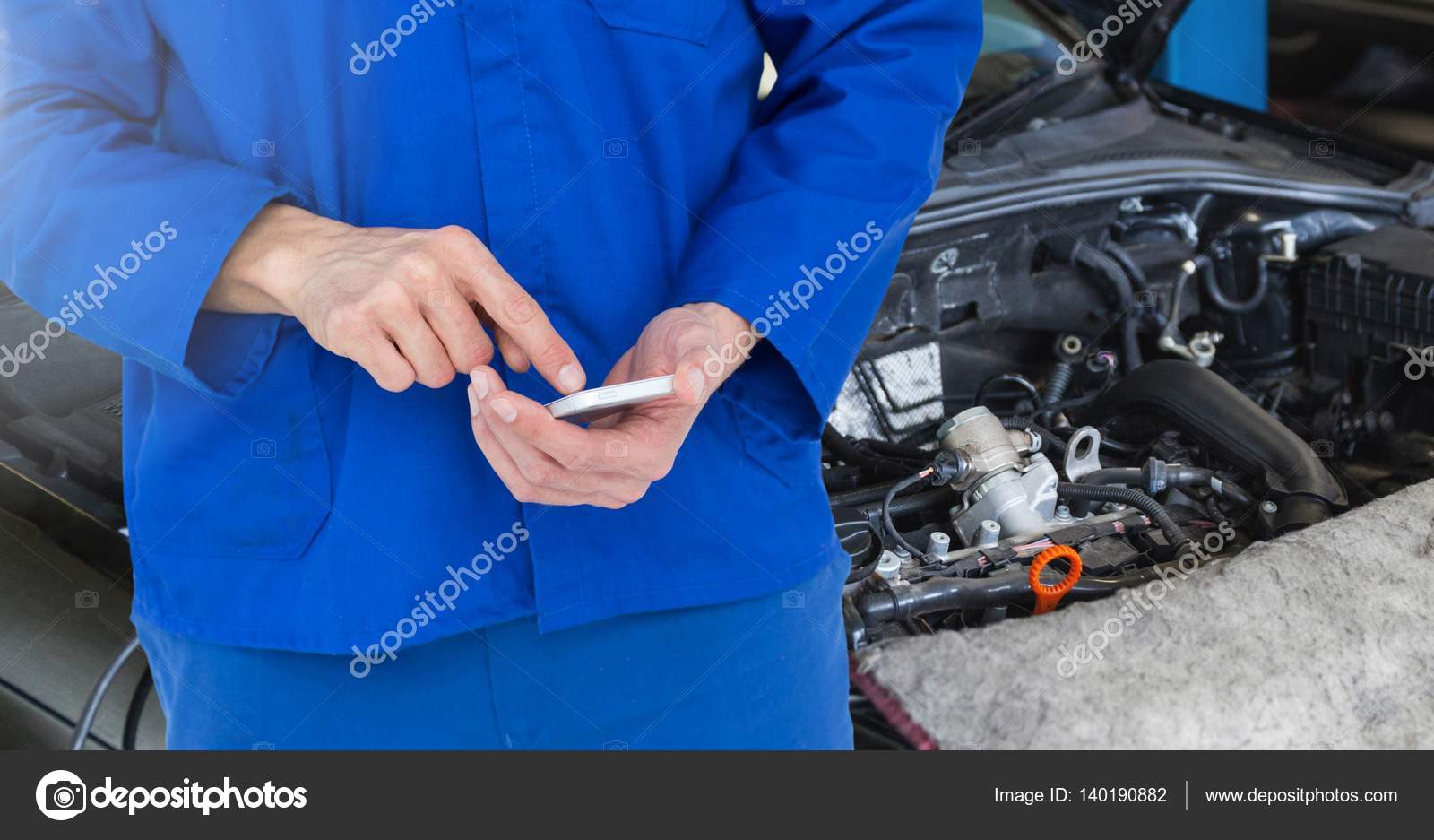 Car mechanic using mobile phone Stock Photo by ©Wavebreakmedia 140190882
