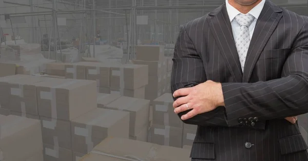 Businessman standing with arms crossed at warehouse — Stock Photo, Image