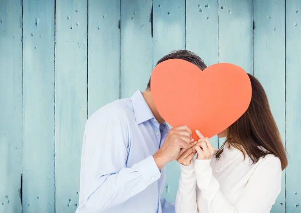 Paar versteckt sein Gesicht hinter rotem Herz — Stockfoto