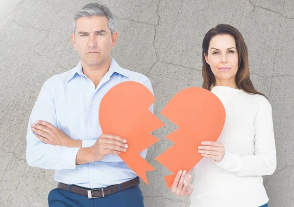 Upset couple holding broken heart — Stock Photo, Image