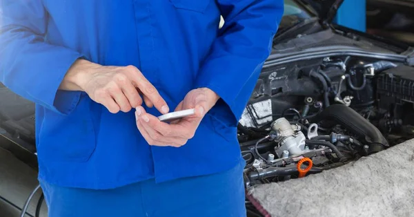 Mechanik samochodowy, przy użyciu telefonu komórkowego — Zdjęcie stockowe