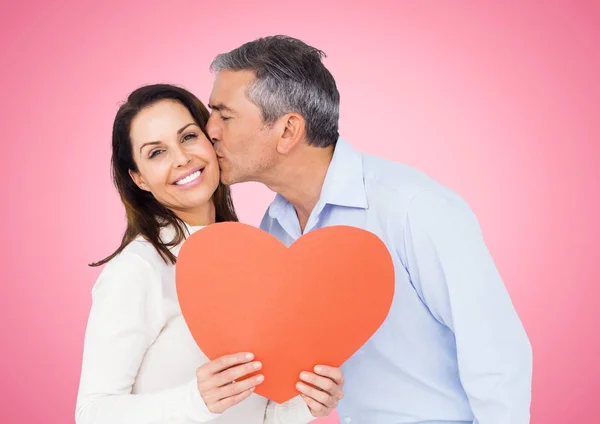 Зрелый мужчина целует женщину с сердцем — стоковое фото