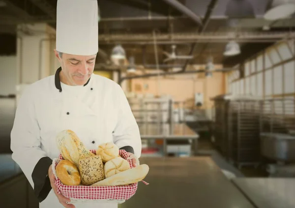 Chef segurando vários loafs de pão — Fotografia de Stock