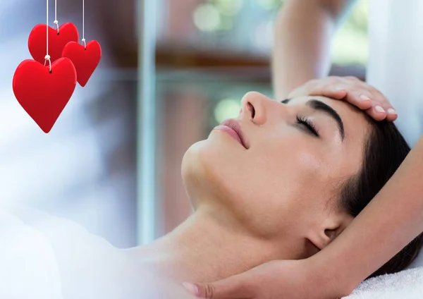 Corações pendurados vermelhos e mulher recebendo massagem — Fotografia de Stock