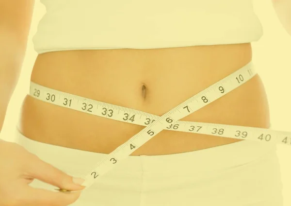 Mulher medindo sua cintura com fita — Fotografia de Stock