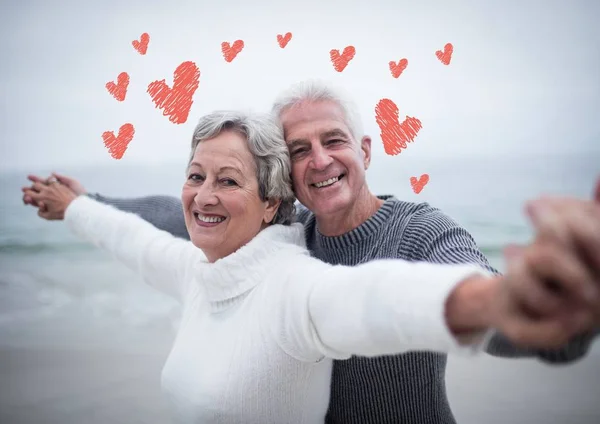 Pareja de ancianos de pie con los brazos extendidos — Foto de Stock