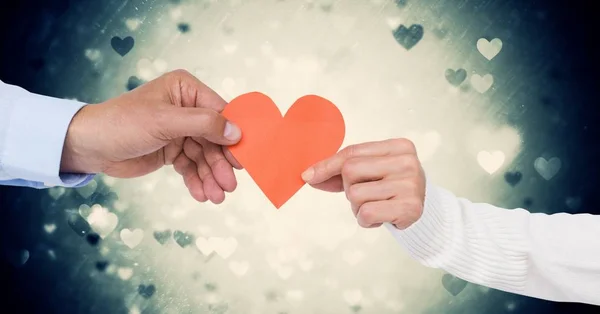 Manos de pareja sosteniendo un corazón — Foto de Stock
