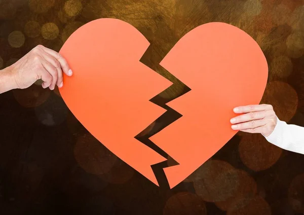 Hands of couple holding a broken heart — Stock Photo, Image