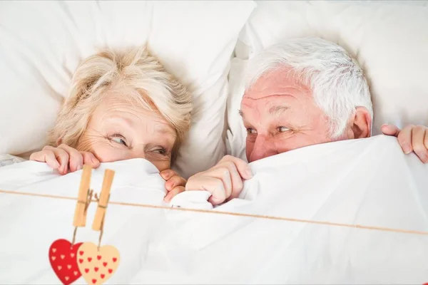 Пара пожилых людей отдыхает на кровати — стоковое фото