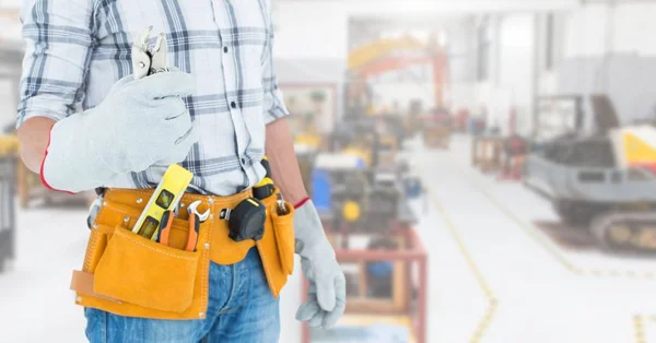 Homme à tout faire avec ceinture à outils à l'atelier — Photo