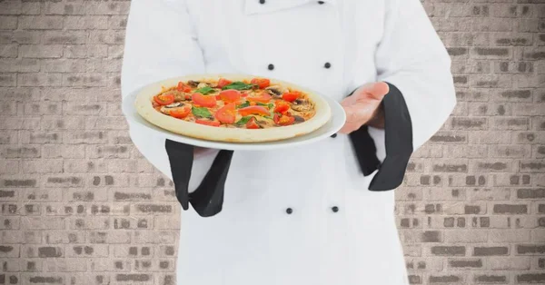 Chef com pizza contra parede de tijolo — Fotografia de Stock