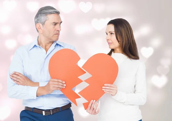 Pareja madura sosteniendo un corazón roto — Foto de Stock