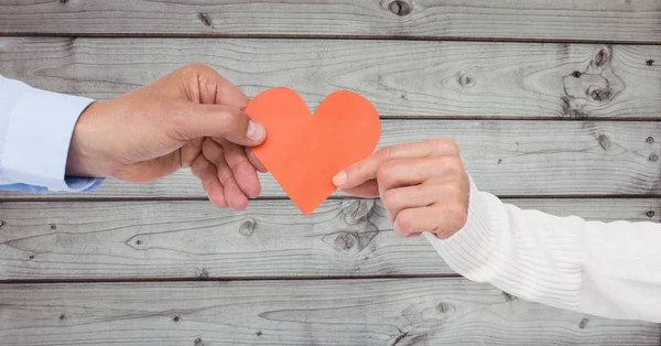 Manos de pareja sosteniendo un corazón — Foto de Stock