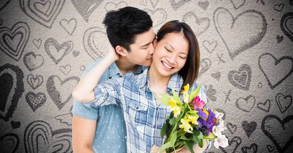 Homem beijando mulher enquanto segurando buquê — Fotografia de Stock