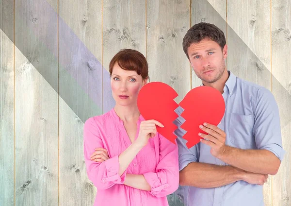Sad couple holding broken hearts — Stock Photo, Image