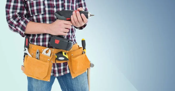 Man with tool belt holding a drill — Stock Photo, Image