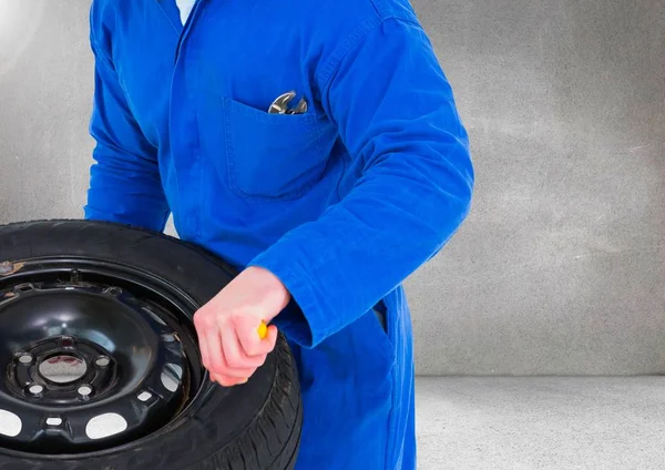 Mechanik drží pneumatiku na garáž — Stock fotografie