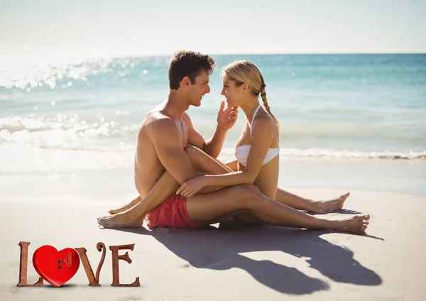 Romantiska par som sitter på stranden — Stockfoto