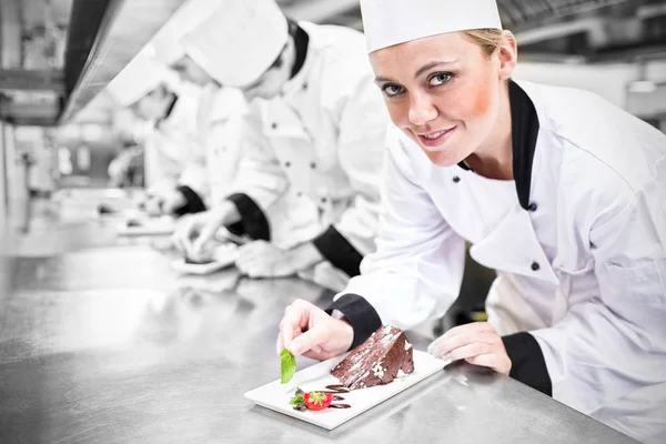 Lachende chef-kok opzoeken van afwerking dessert — Stockfoto