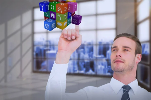 Composite image of cheerful businessman pointing cube with his finger — Stock Photo, Image